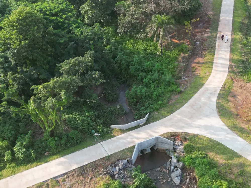 Aerial view of a concrete path and culvert surrounded by green vegetation