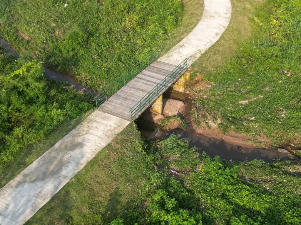 Footbridge and concrete path over a drainage channel at Maitama Amusement Park