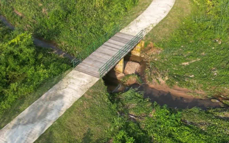 Footbridge and concrete path over a drainage channel at Maitama Amusement Park