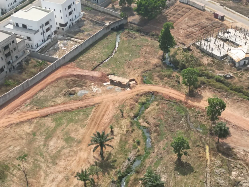 Drainage channel and retaining wall beside open land in Maitama