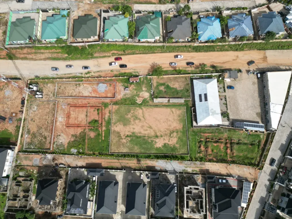 Aerial view of a plot with foundations being set out beside completed homes