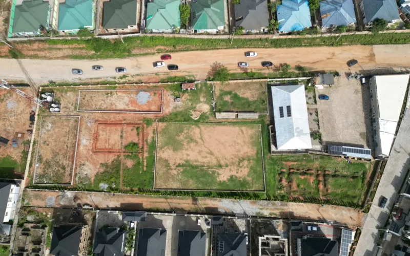 Aerial view of a plot with foundations being set out beside completed homes