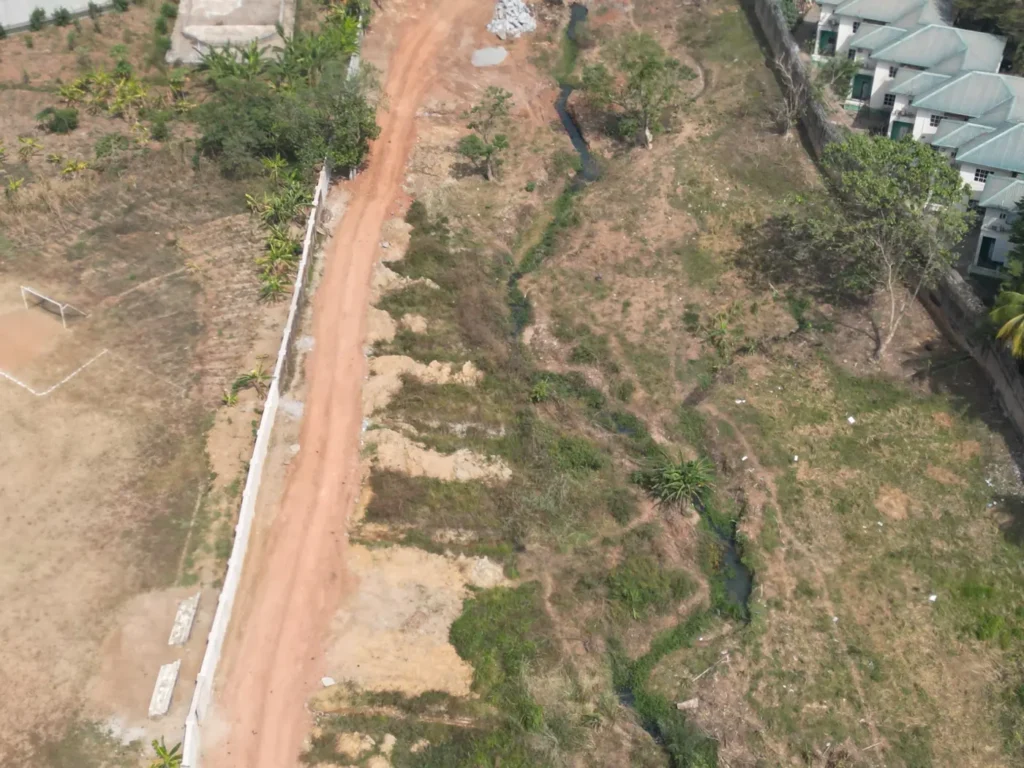 Eroding gully beside a boundary wall that needs drainage